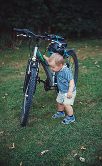 Boy riding bicycle on field