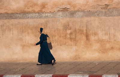 Rear view of women standing on wall