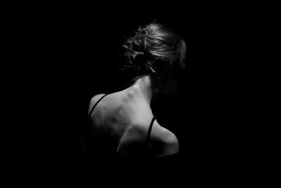 Rear view of woman against black background