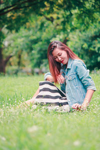 Young woman sitting on grass in field