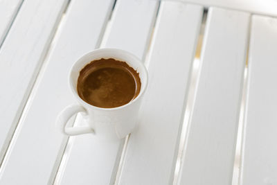 Espresso in white coffee cup on wood table nature background close up in the morning