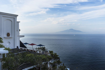 Scenic view of sea by buildings against sky