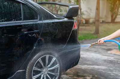 Car washing. cleaning car wheel using high pressure water.
