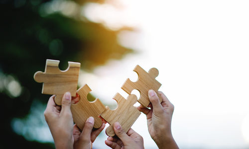 Cropped hands of woman holding jigsaw puzzle