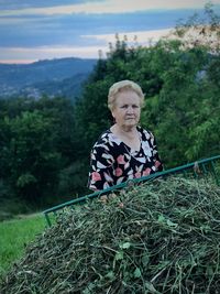 Portrait of woman against plants on field