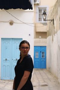 Portrait of woman standing against wall
