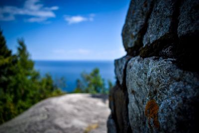 Close-up of rocks by sea against sky