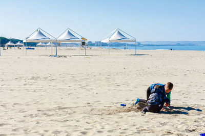 Boy on beach against sky