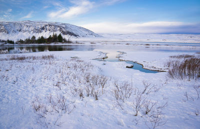 Scenic view of frozen lake against sky during winter