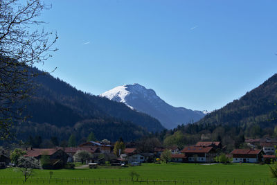 Scenic view of houses and mountains against sky