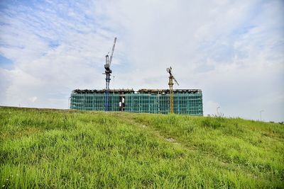 Low angle view of windmill on field against sky