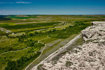 High angle view of road amidst field against sky