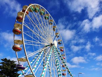 Low angle view of ferris wheel against blue sky