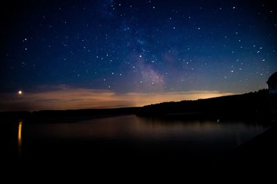 Scenic view of lake against sky at night