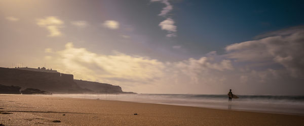 Scenic view of beach against sky during sunset