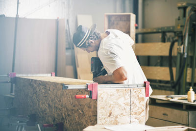 Male carpenter making furniture at workshop