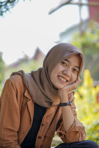 Close-up of a muslim woman wearing a headscarf with her hand resting on her cheek