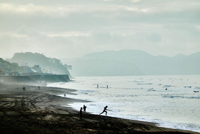 People on beach against sky