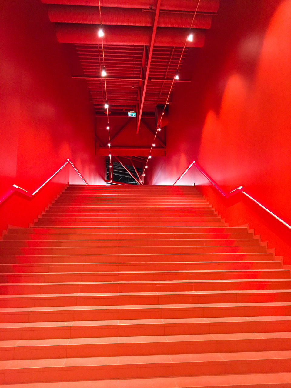 red, staircase, steps and staircases, architecture, stage, lighting equipment, indoors, illuminated, light, the way forward, no people, built structure, railing, line, stairs, auditorium, ceiling, light - natural phenomenon, diminishing perspective