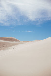 Sand dunes in desert against sky