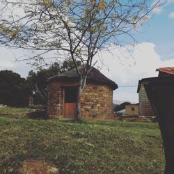 Abandoned house on field against sky