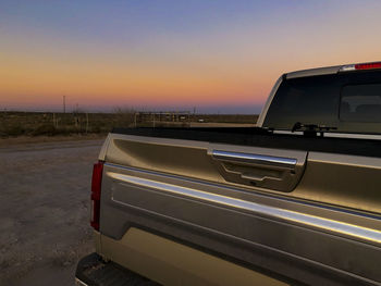 Work truck sits on dirt road at sunset west texas