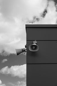 Low angle view of electric lamp against sky