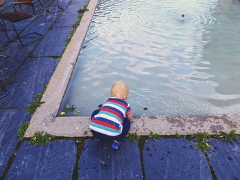 High angle view of boy by swimming pool