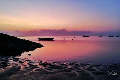 Scenic view of sea against dramatic sky during sunset