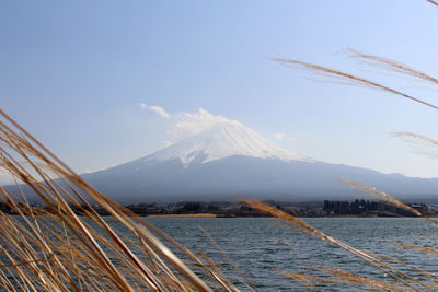 Scenic view of sea by mountains against sky