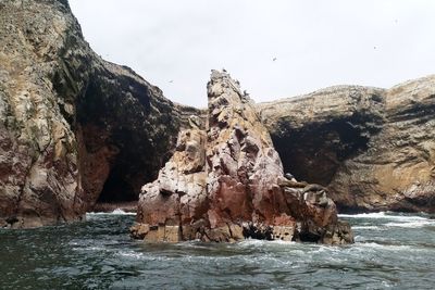 Rock formations by sea against sky