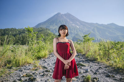 Full length of woman standing on rocks against mountain
