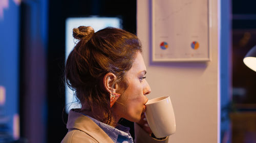 Young woman drinking coffee at home