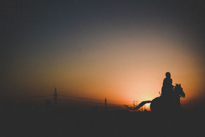 Silhouette of man riding at dusk