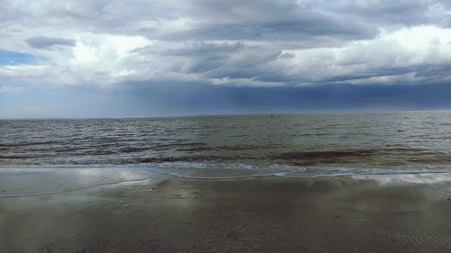 Scenic view of sea against cloudy sky