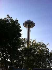 Low angle view of water tower and trees against sky