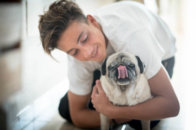 Portrait of dog with teenage boy at home