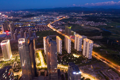 High angle view of illuminated modern buildings in city at night