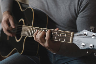 Midsection of man playing guitar