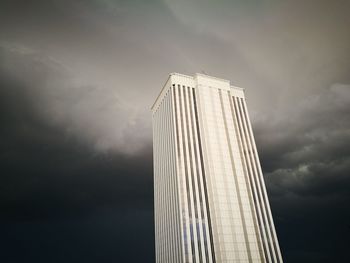 Low angle view of modern building against cloudy sky