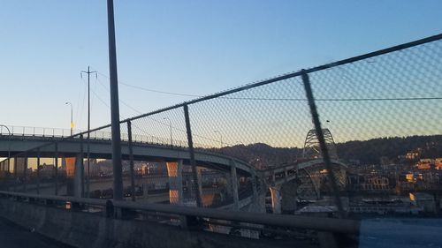 Bridge over river in city against clear sky