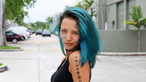 Side view portrait of young woman standing in city