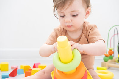 Close-up of boy playing with toy blocks against white background