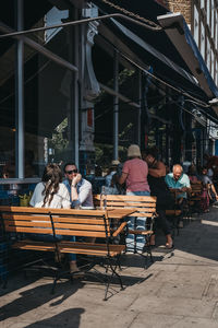 People sitting at outdoor cafe in city