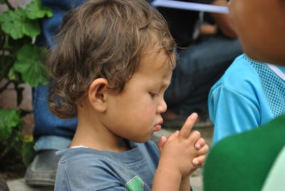 Close-up of thoughtful boy with hands clasped