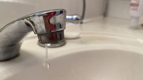 Close-up of water faucet in bathroom