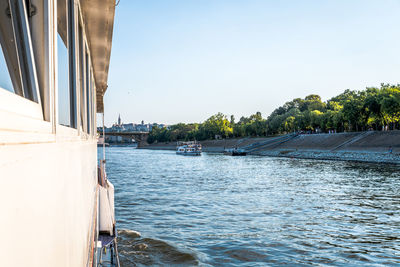 Yacht sailing on river against sky