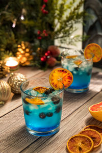 Ocean breeze cocktails garnished with blueberries and spiced dried oranges.