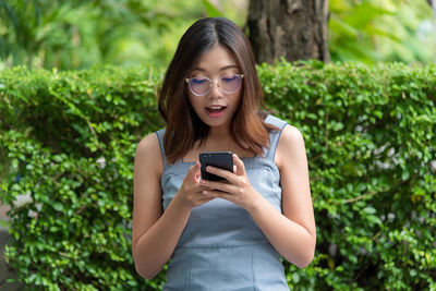 Young woman using smart phone outdoors