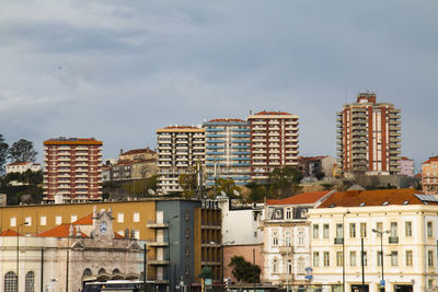 Buildings in city against cloudy sky